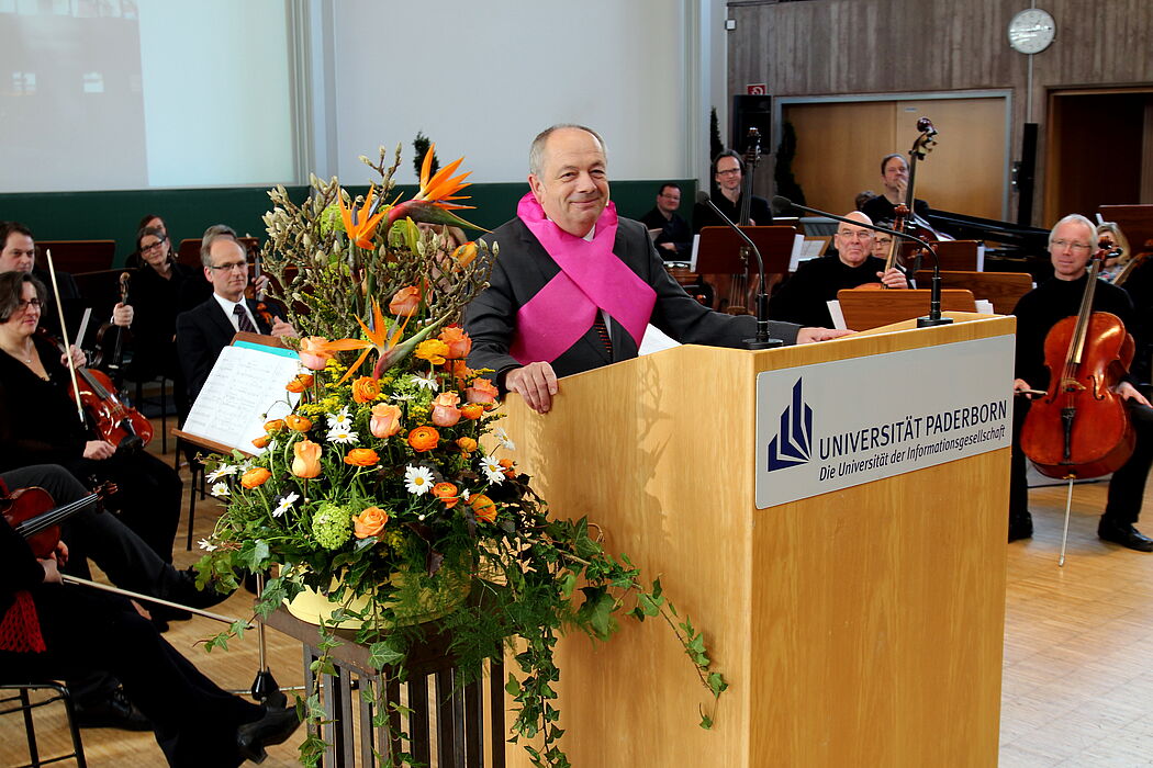 Foto (Universität Paderborn, Nina Reckendorf): Überraschungsgeschenk: Kabarettist Eckhard Radau, ehemaliger Schulkamerad Rischs, gab einen satirischen Rückblick auf dessen Amtszeit.
