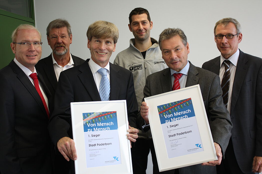 Foto (Universität Paderborn, Patrick Kleibold): Zur Übergabe der Urkunden waren anwesend: Karl-Julius Sänger (TK) (v.l.), Dieter Thiele (Leiter Hochschulsport), Prof. Dr. Nikolaus Risch (Präsident der Uni Paderborn), Daniel Lieneke (Paderborner Basket