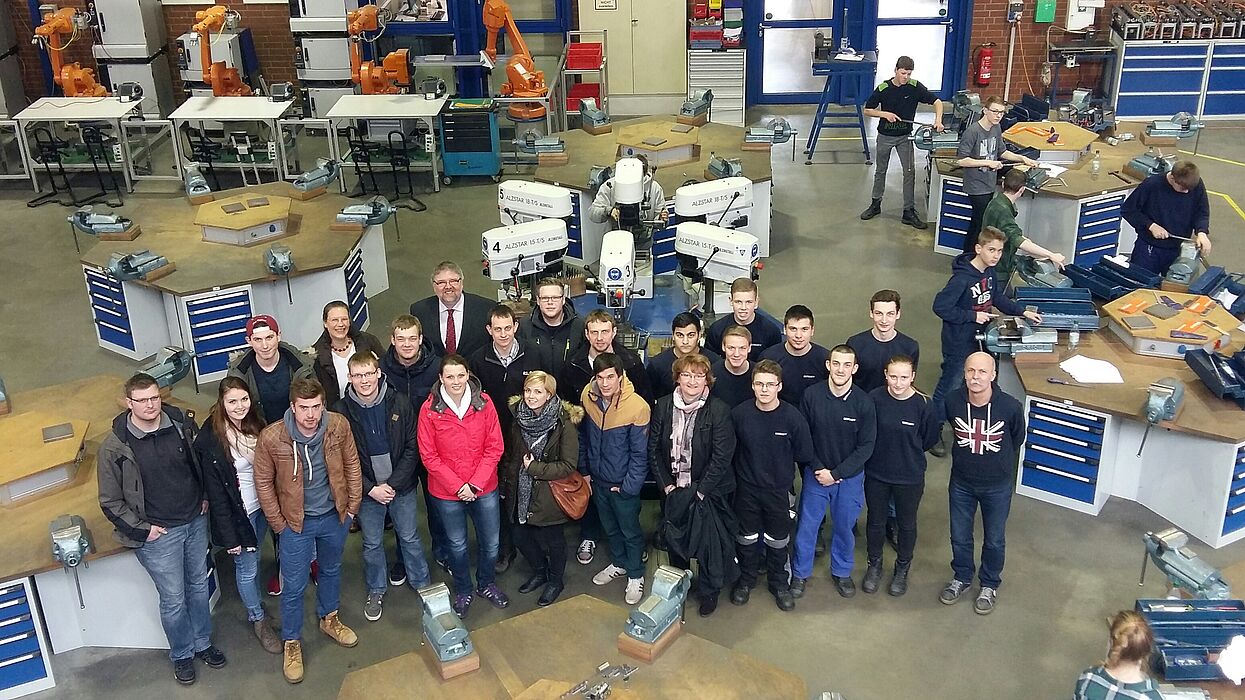 Foto (Universität Paderborn,  Fachgebiet Technikdidaktik): Lehramtsstudierende der Universität Paderborn und Auszubildende im Aus- und Weiterbildungszentrum der Firma Benteler, begleitet von Prof. Katrin Temmen (letzte Reihe, 2. v. l.) und Ausbildungsle