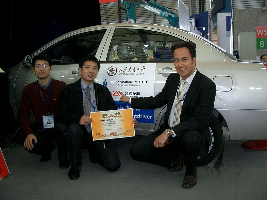 Foto: Auszeichnung als bester Universitätsmessestand auf der 7. Shanghai International Industry Fair (v. li.): He Qichang und Dr. Wu Dianliang (Shanghai Jiao Tong Universität) sowie Sven-Kelana Christiansen vom Heinz Nixdorf Institut (HNI) der Universit