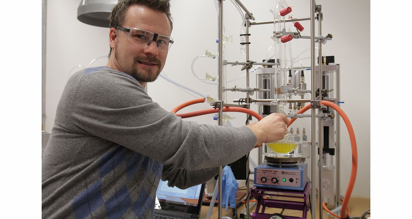 Foto (Universität Paderborn, Nina Reckendorf): Prof. Dr. Matthias Bauer vor der Apparatur zur Spaltung von Wasser