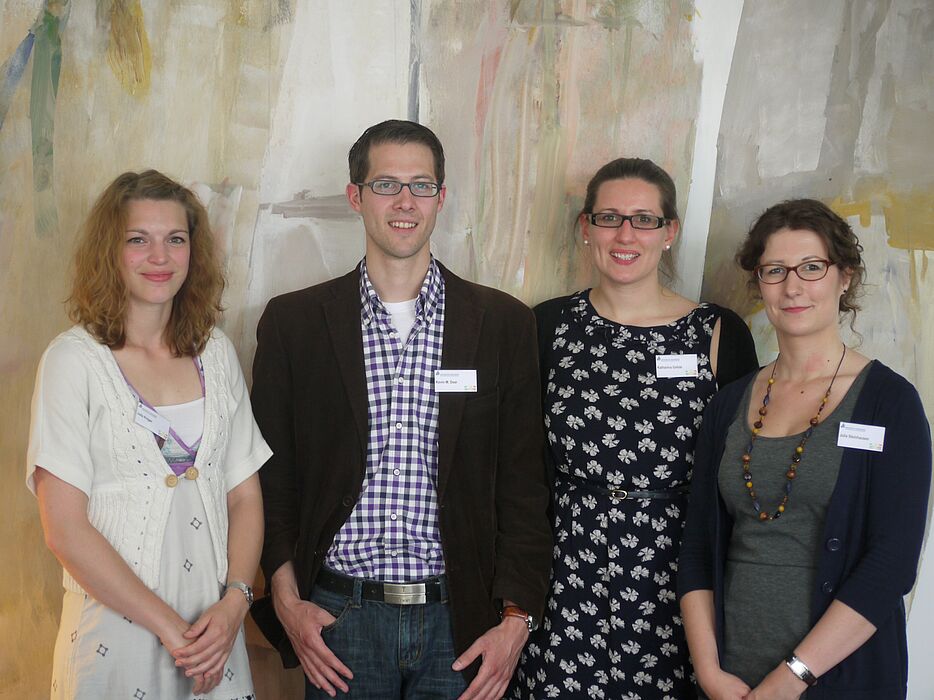 Foto (Universität Paderborn, Heike Probst): (v. l. n. r.): Staffelholzübergabe der Graduiertensprecherinnen und -sprecher: Julia Kröger, Kevin M. Dear, Katharina Gefele und Julia Steinhausen.