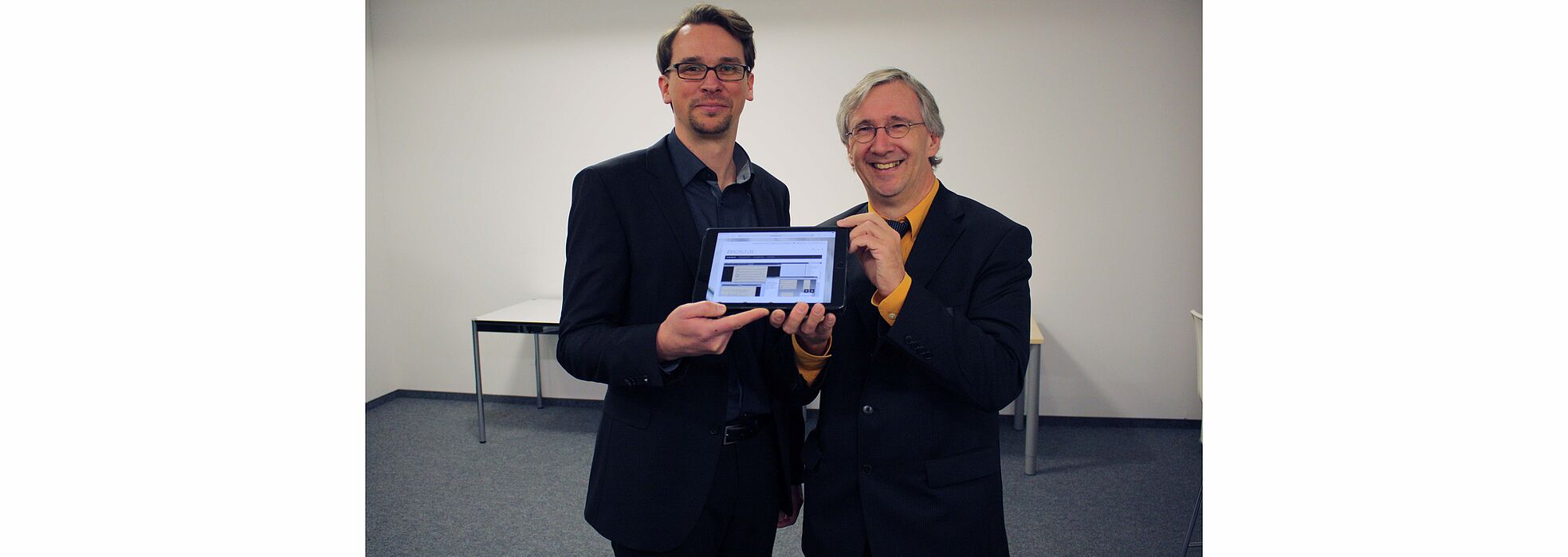Foto (Musikhochschule Detmold, Friedrich von Plettenberg): Zukünftig werden Musiker vom Tablet spielen anstatt vom Blatt: Dipl. Wirt.-Inf. Daniel Röwenstrunk (l.) und Prof. Dr. Joachim Veit (r.) vom Kompetenzzentrum "Musik-Edition-Medien" präsentieren 