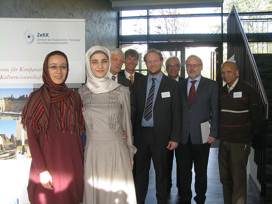 Abbildung: vorne: Dr. des. Muna Tatari und Dr. des. Tuba Isik; hinten: Bürgermeister Heinz Paus, Prof. Dr. Nikolaus Risch, Prof. Dr. Klaus von Stosch, Emin Özel, Prof. Dr. Volker Peckhaus, Prof. Dr. Farid Esack.