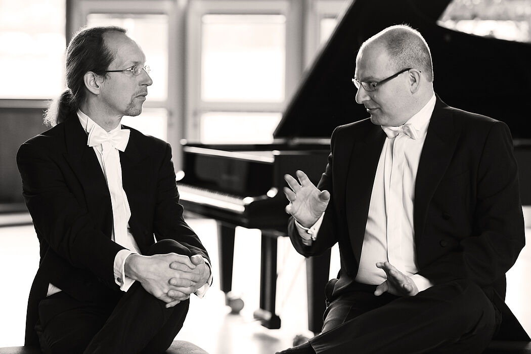 Foto (A. Rutenburges, Uni Paderborn): Im Gespräch: Pianist Eckhard Wiemann (li.) und Dirigent Steffen Schiel – zusammen mit dem Hochschulorchester Paderborn führen sie Griegs Klavierkonzert auf.