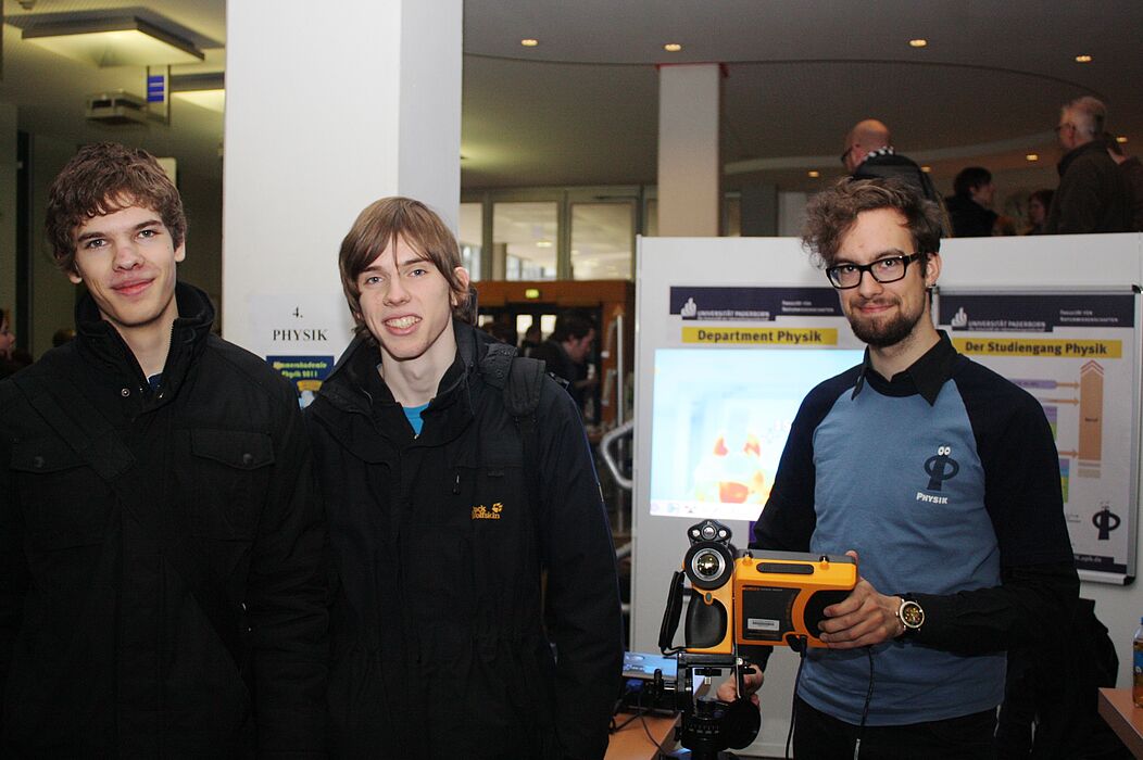 Foto (Universität Paderborn, Patrick Kleibold): (v.l.): Steffen Ridderbusch und Philip Georgi lassen sich von Johannes Pauly, Physikstudent, eine Wärmebildkamera erklären. Beide interessieren sich für ein Physikstudium.