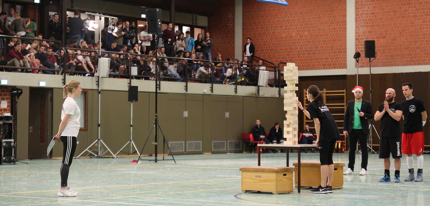 Foto (Universität Paderborn, Björn Heerdegen): Volle Konzentration: Auch das Publikum hält den Atem an, als Carolin Köster bei „Riesenjenga“ nach dem richtigen Stein sucht.
