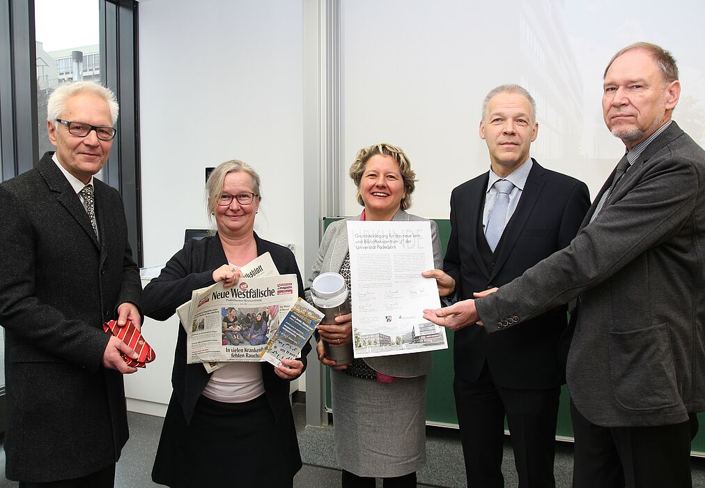 Foto (Universität Paderborn, Vanessa Dreibrodt): (v. l.) Befüllten gemeinsam die Zeitkapsel mit Tageszeitungen, Bauplan und Münzen: Martin Pantke, stellv. Bürgermeister Stadt Paderborn, Simone Probst, Vizepräsidentin der Universität Paderborn, Svenj