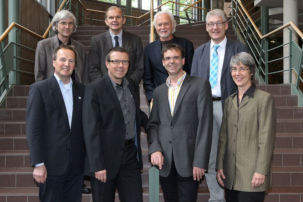 Foto (Uni Paderborn, A. Rutenburges):  (obere Reihe von l.) Dr. Frank Lohse, Prof. Dr. Helmut Heseker, Prof. Dr. Hans-Joachim Warnecke, Prof. Dr. Peter Reinhold  übergeben an (untere Reihe von l.) Dr. Christian Hennig,  Prof. Dr. Hans Peter Brandl-Breden