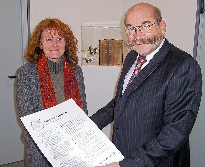 Foto (Mark Heinemann): Die Universität Paderborn ist auf dem Weg zur familiengerechten Hochschule. Die Gleichstellungsbeauftragte Irmgard Pilgrim und Uni-Kanzler Jürgen Plato freuen sich über die von der "Beruf & Familie gGmbH", einer gemeinnützigen I
