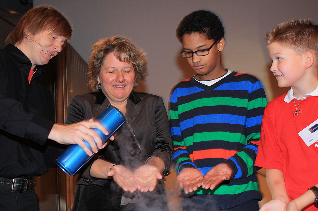Foto (Referat Presse und Kommunikation, Universität Paderborn, Frauke Döll): Wissenschaftler der Uni Paderborn machen mit der Event-Physik Lust auf Experimente: Dr. Marc Sacher gießt Svenja Schulze flüssigen Stickstoff über die Hand… – Kalt, Frau
