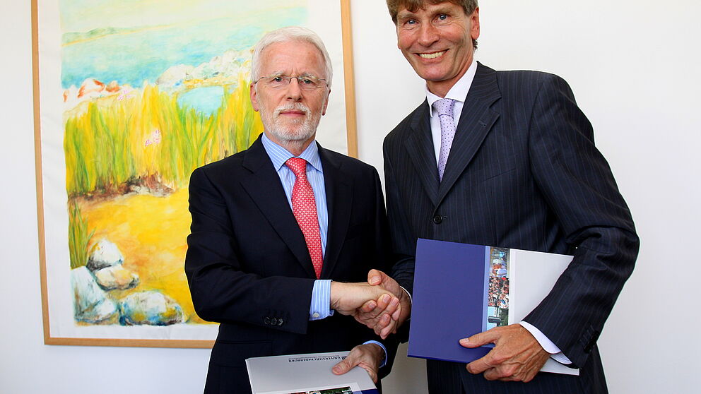 Foto (Universität Paderborn, Patrick Kleibold): Dr.-Ing. Herbert Hanselmann (links), geschäftsführender Gesellschafter der dSPACE GmbH Paderborn, und Prof. Dr. Nikolaus Risch, Präsident der Universität Paderborn, nach der Unterzeichnung des Vertrages