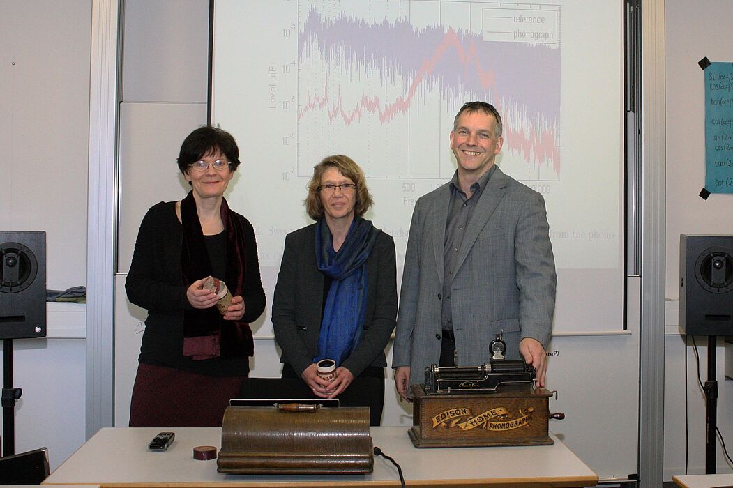Foto: Auf der Suche nach dem historischen Klang der Stimme: Prof. Dr. Rebecca Grotjahn, Dr. Karin Martensen und Prof. Dr.-Ing. Malte Kob vor einer akustischen Klanganalyse eines Edison-Phonographen. © HfM Detmold/Plettenberg