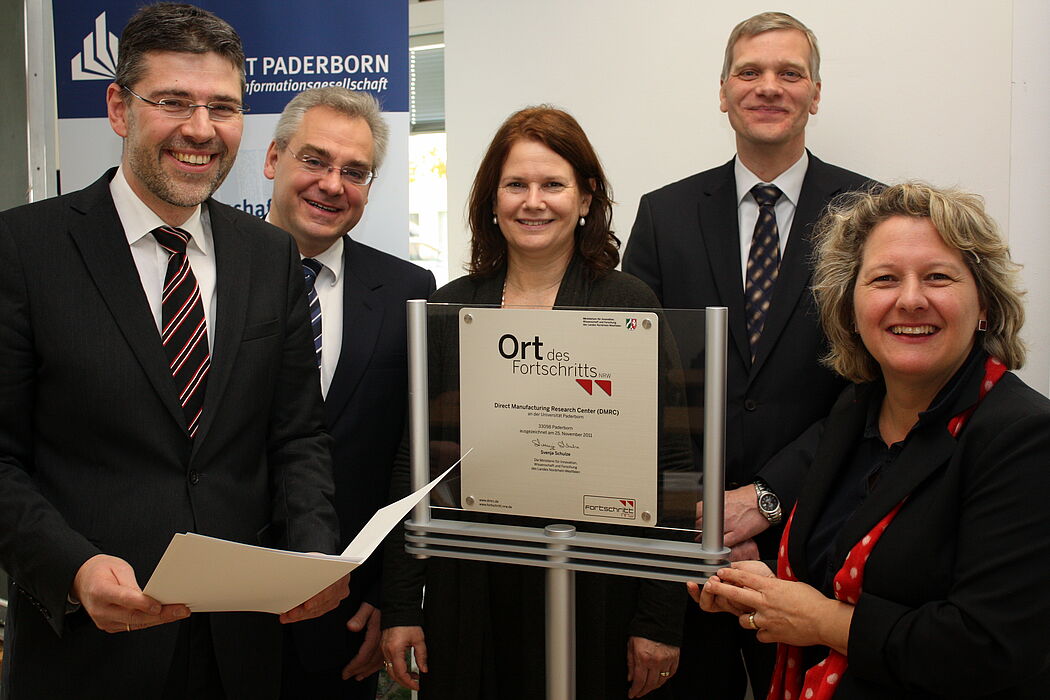 Foto (Universität Paderborn, Patrick Kleibold): Die NRW-Wissenschaftsministerin Svenja Schulze (r.) hat zusammen mit Prof. Dr.-Ing. Hans-Joachim Schmid (v. l.), Dr. Eric Klemp, Prof. Dr. Dorothee M. Meister und Prof. Dr. Volker Schöppner die Plakette en
