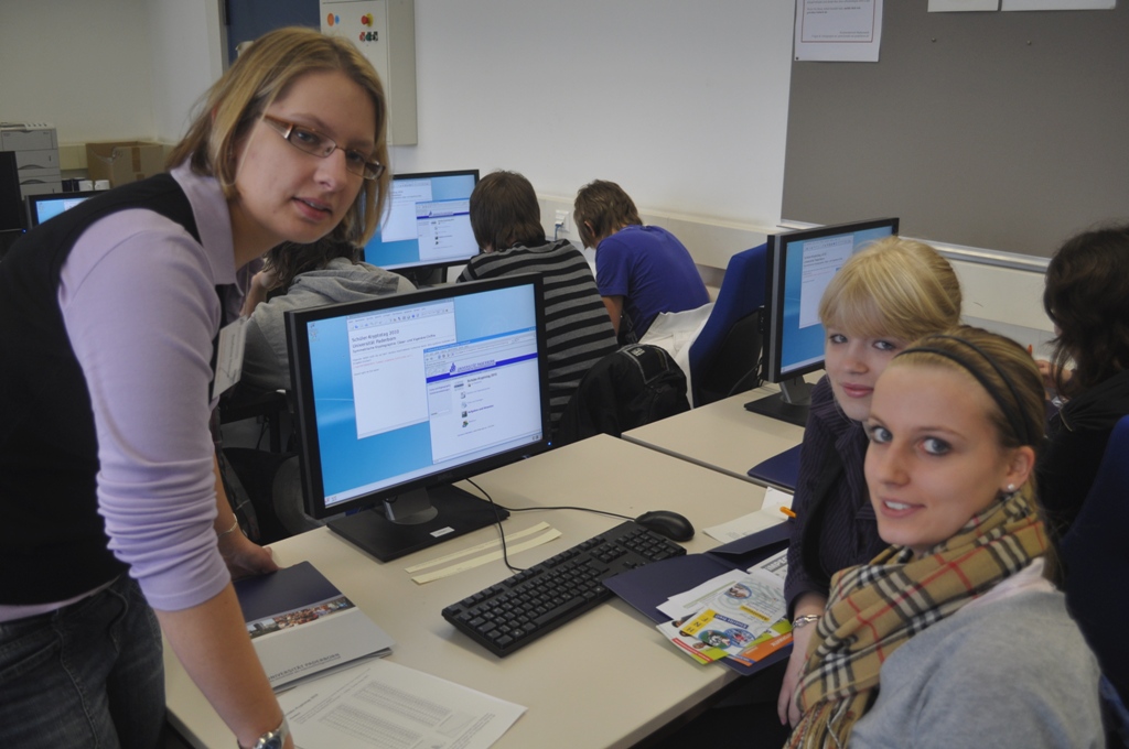 Foto (Mark Heinemann): Der Verschlüsselung auf der Spur: Stefanie Naewe aus dem Institut für Informatik mit Teilnehmerinnen des Schüler-Kryptotages.