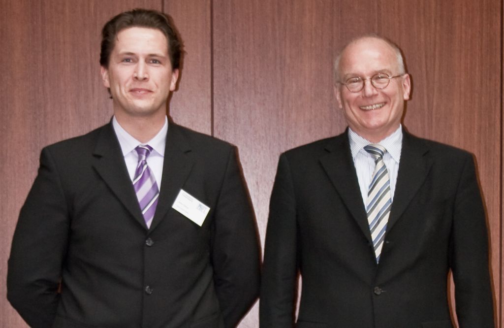 Foto (Universität Paderborn): Prof. Dr.-Ing. habil. Wilhelm Dangelmaier (re.) freut sich mit seinem Doktoranden, Robin Delius (li.), über das Stipendium aus der Industrie.