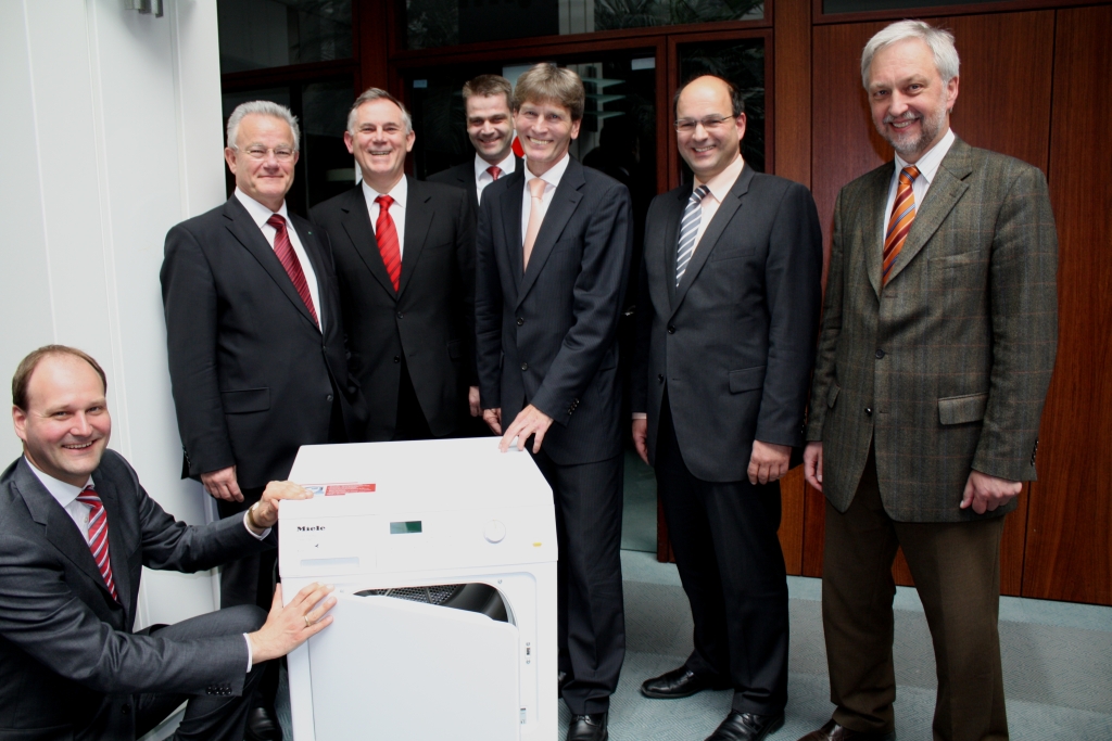 Foto: Freuten sich gemeinsam über die neue Projektgruppe, die unter anderem an der Weiterentwicklung solcher vollautomatischer Wäschetrockner arbeiten wird (v. l.): Dr. Markus Miele von der Miele & Cie. KG, Prof. Dr. Hans-Jörg Bullinger, Präsident der