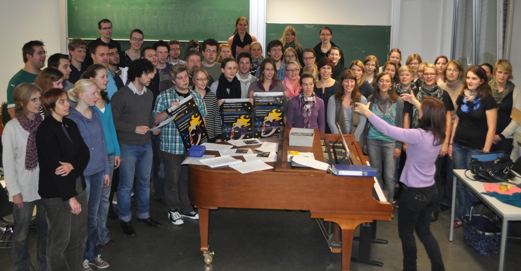 Foto (Universität Paderborn, Mark Heinemann): Es wird fleißig geübt: Die Sängerinnen und Sänger von UniSono proben unter der Leitung von Gundula Hense (am Klavier) bereits seit April für das Adventskonzert.