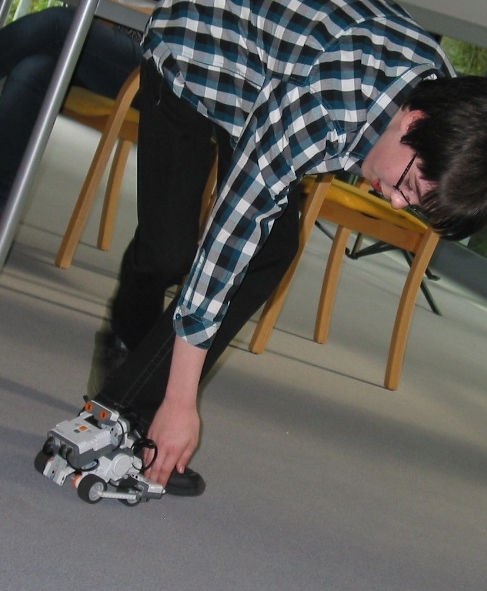 Foto: Daniel stellt seinen selbstprogrammierten Roboter vor.